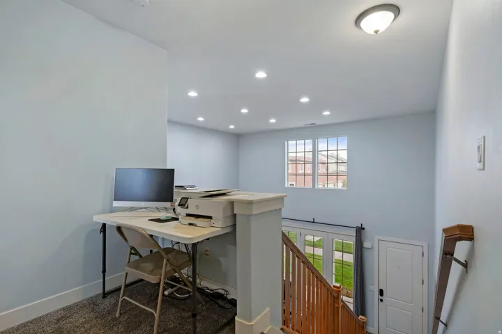 Upper-level landing featuring a window with grid patterns, recessed lighting, and a semi-flush mount ceiling fixture