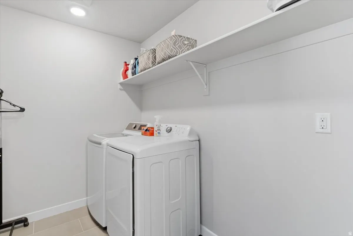 Dedicated utility space featuring light-toned walls, recessed ceiling lighting, and tile flooring