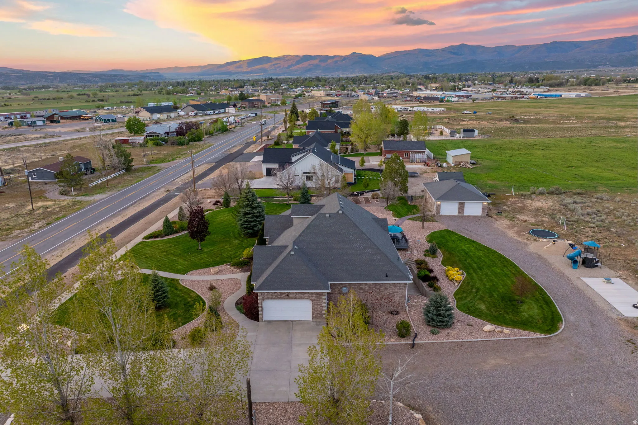 Aerial perspective showcasing a single-story residence with a dark shingle roof and brick facade