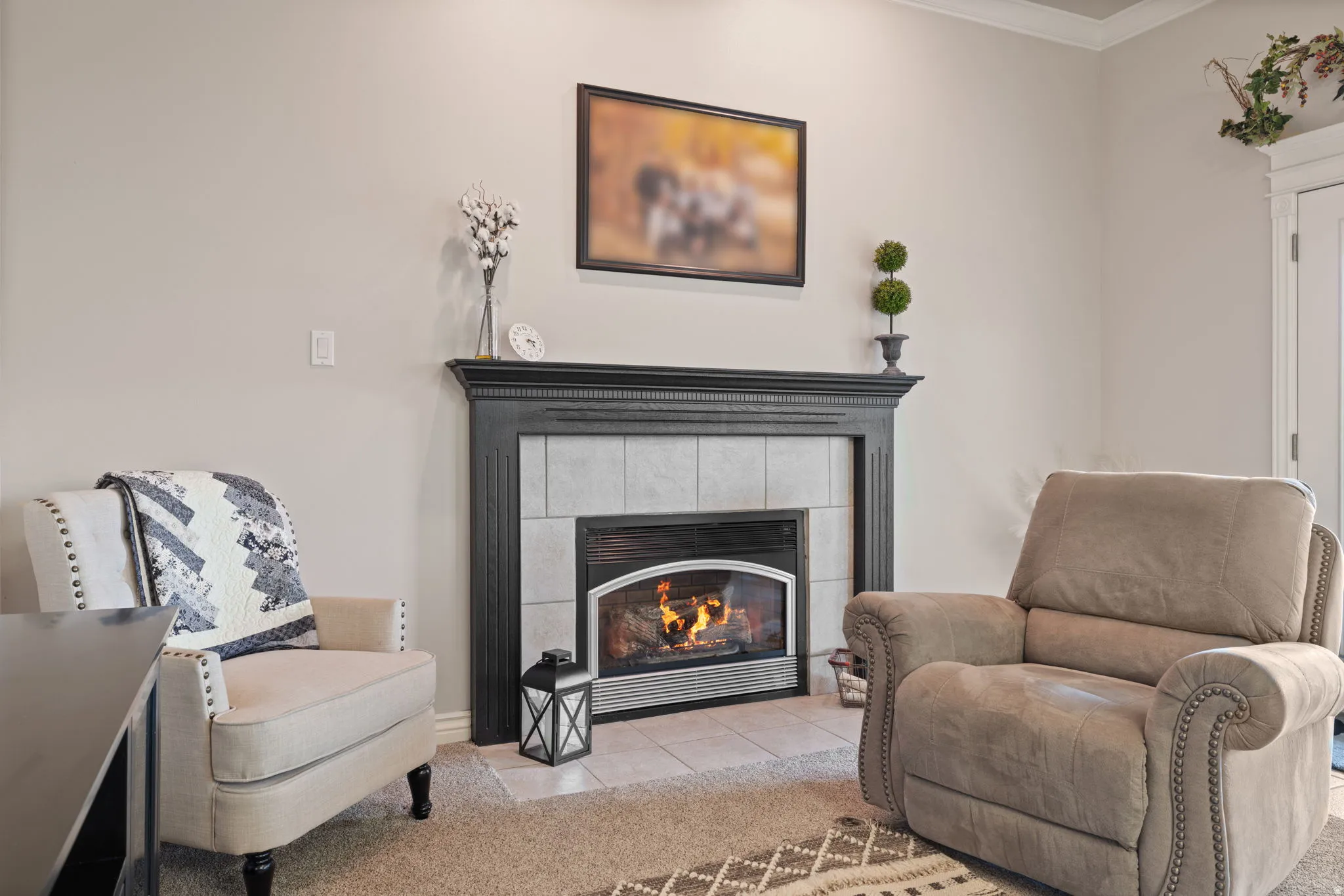 Fireplace featuring a dark wood mantelpiece and a light-toned tile surround