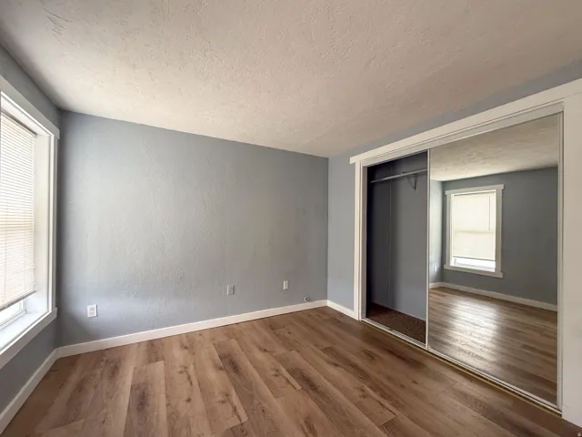 Room featuring wood-finish flooring, light blue walls, and white trim