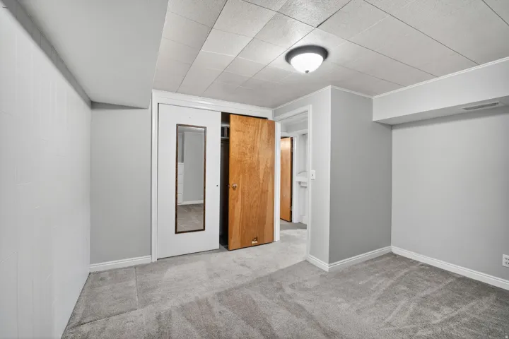 Interior space featuring plush grey carpeting and white baseboards