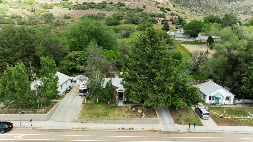 Residential property featuring a sloping terrain and a backdrop of verdant hillsides