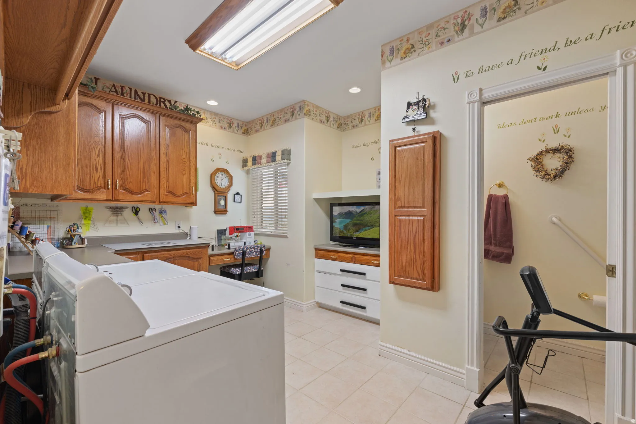 Laundry room featuring wood-finish cabinetry, a built-in countertop, and a window with horizontal blinds