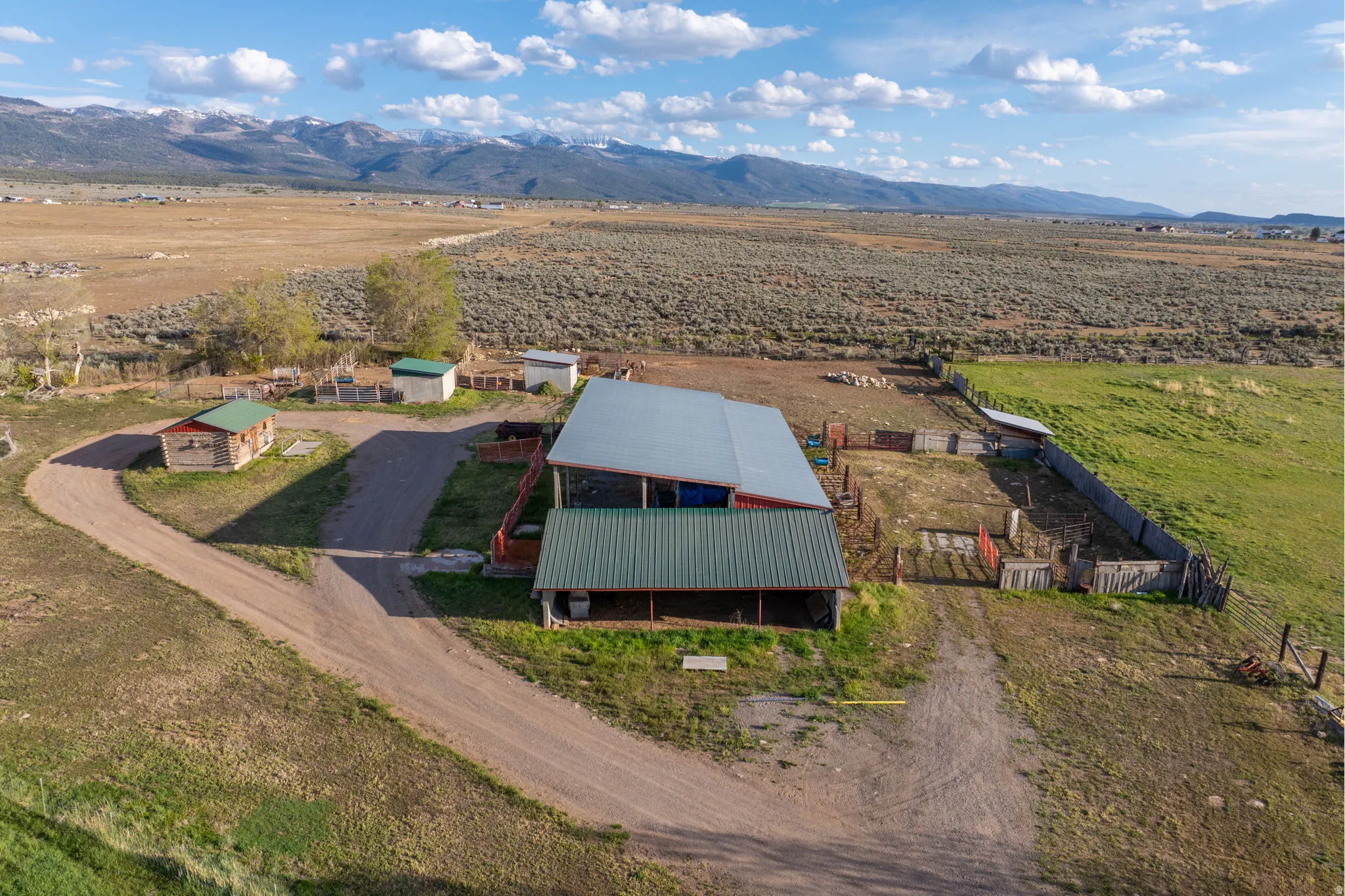 Large barn with horse stalls, tack shed, two cement horse shelters, and open grazing pasture