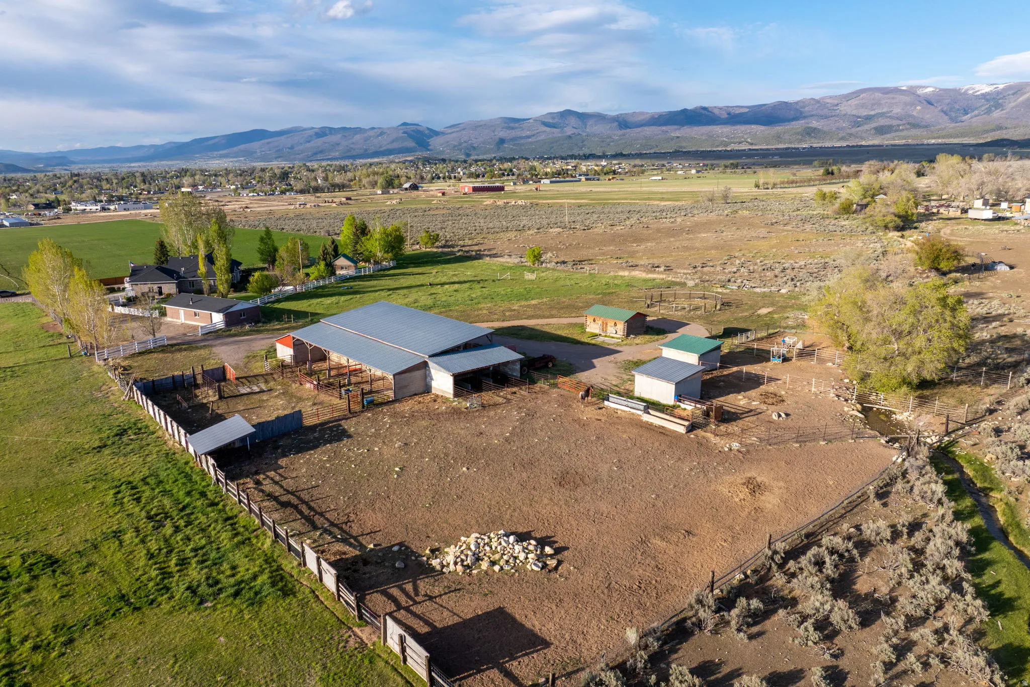 Large barn with horse stalls, tack shed, two cement horse shelters, a spacious detached workshop/garage and open grazing pasture