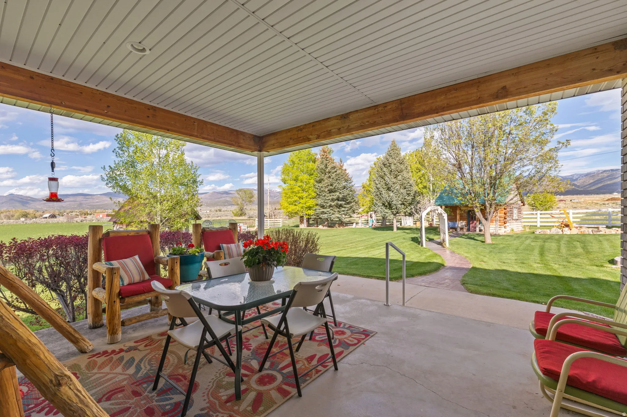 Spacious covered patio with concrete flooring and wood beam accents