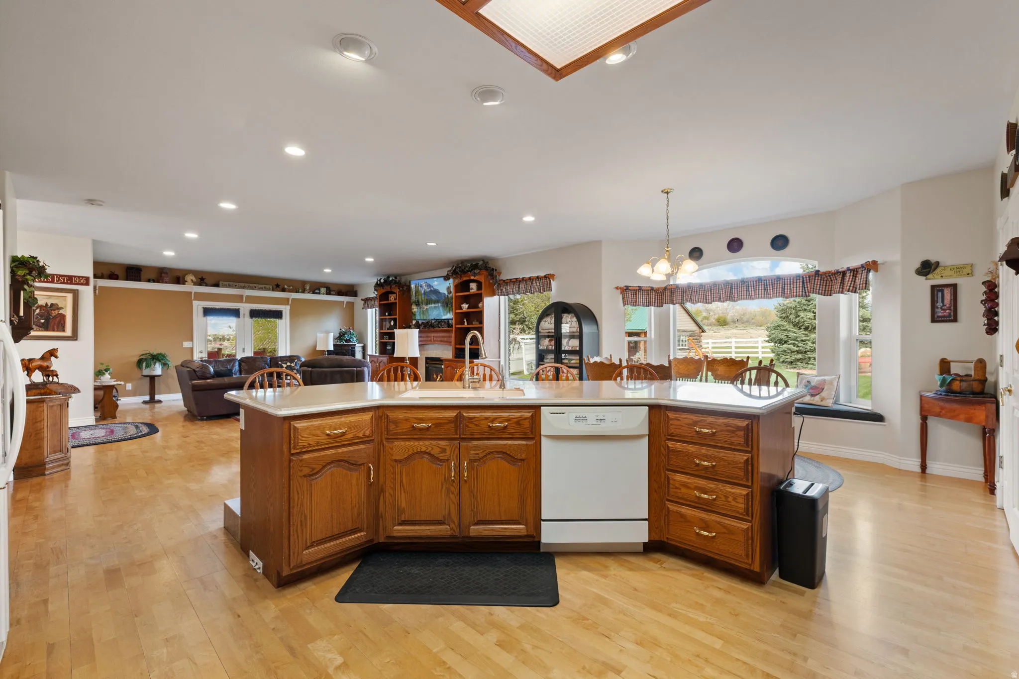 Kitchen island featuring a built-in sink, dishwasher, and wood cabinetry