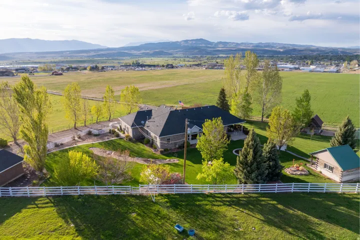Expansive property featuring a multi-level residence with a dark roof and light-colored siding