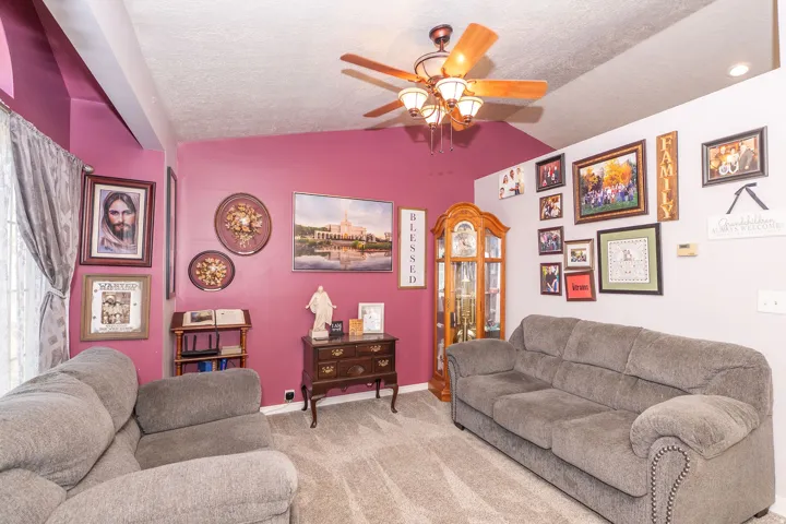 Carpeted interior space featuring a ceiling fan with integrated lighting, vaulted ceiling, and recessed lighting