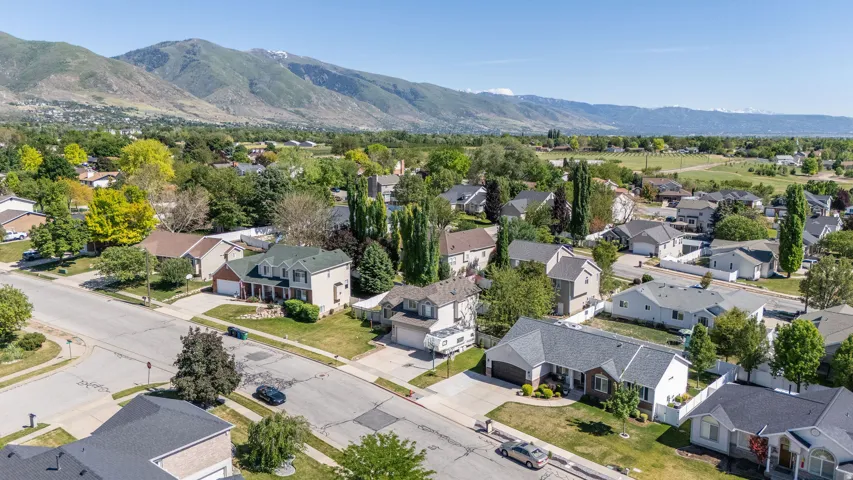 Neighborhood setting with mature trees and mountain backdrop