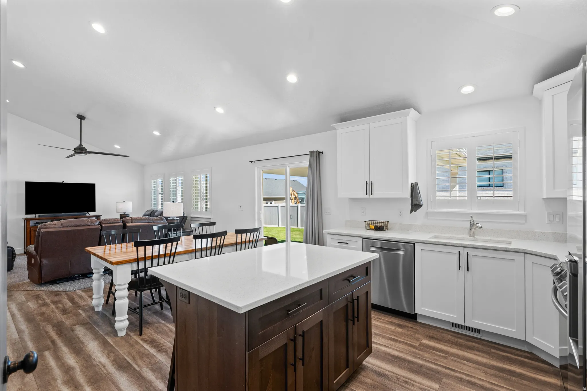 Spacious kitchen with white shaker cabinetry, stainless steel dishwasher, and a center island with a white countertop