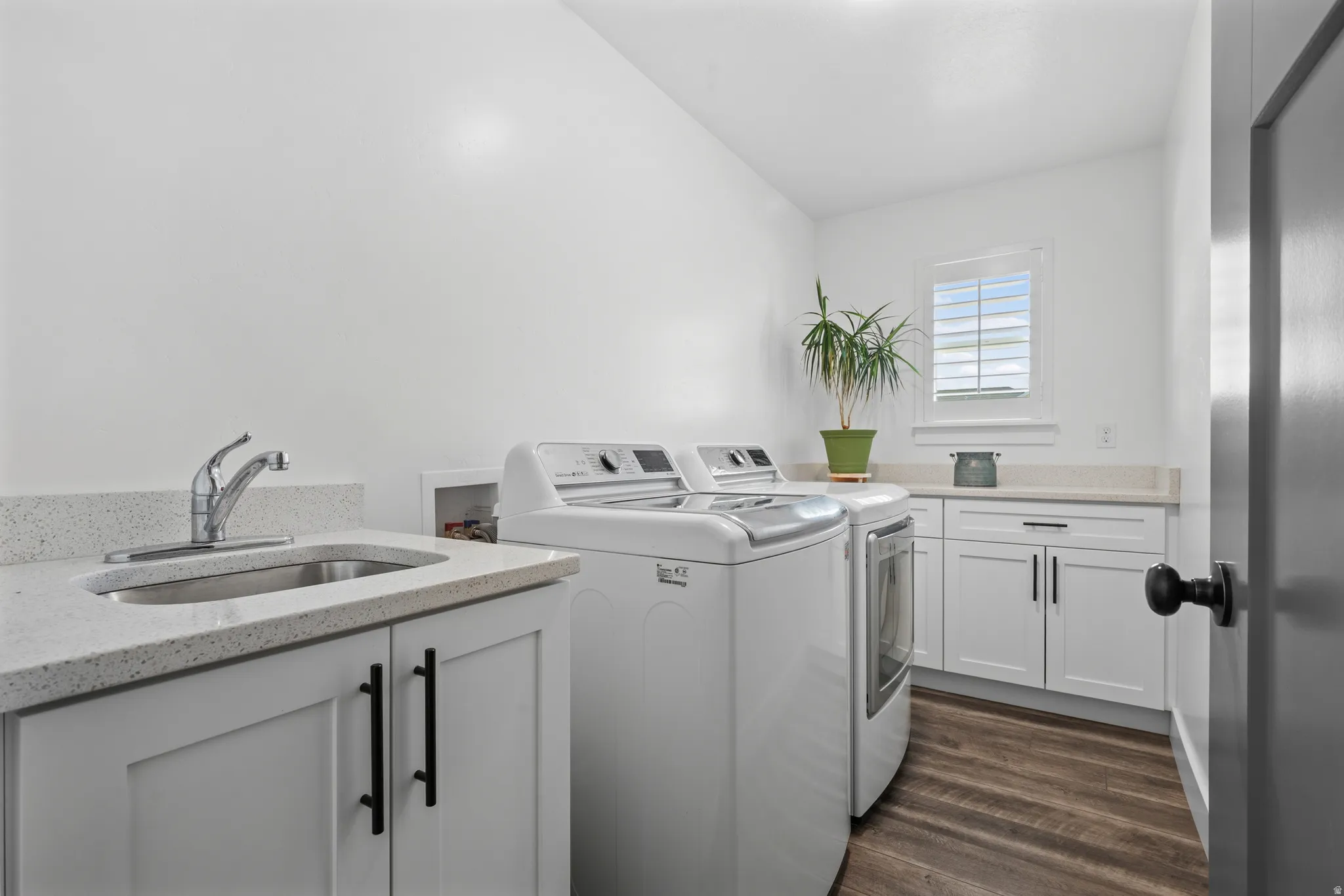 Utility room featuring wood-finish flooring and white walls