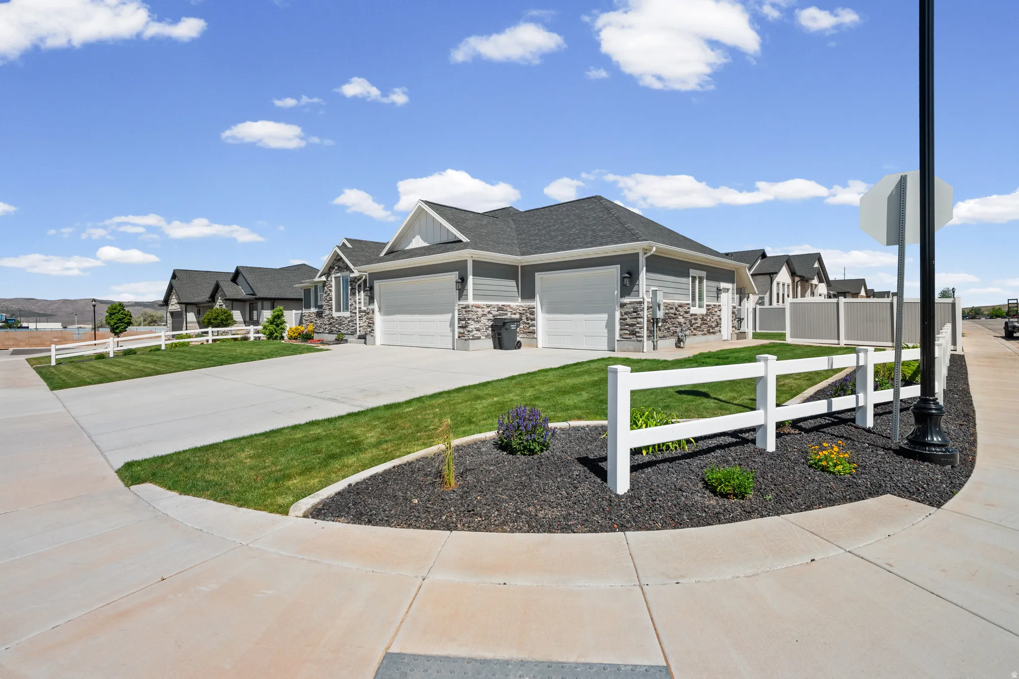 Modern exterior featuring gray siding, stone accents, and a dark shingle roof