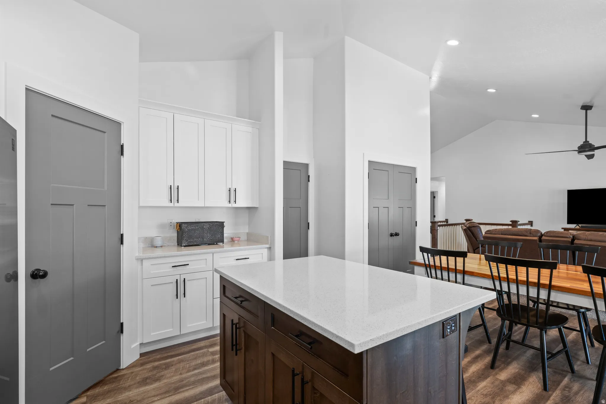 Contemporary kitchen island featuring a light-toned countertop and rich wood-finish cabinetry