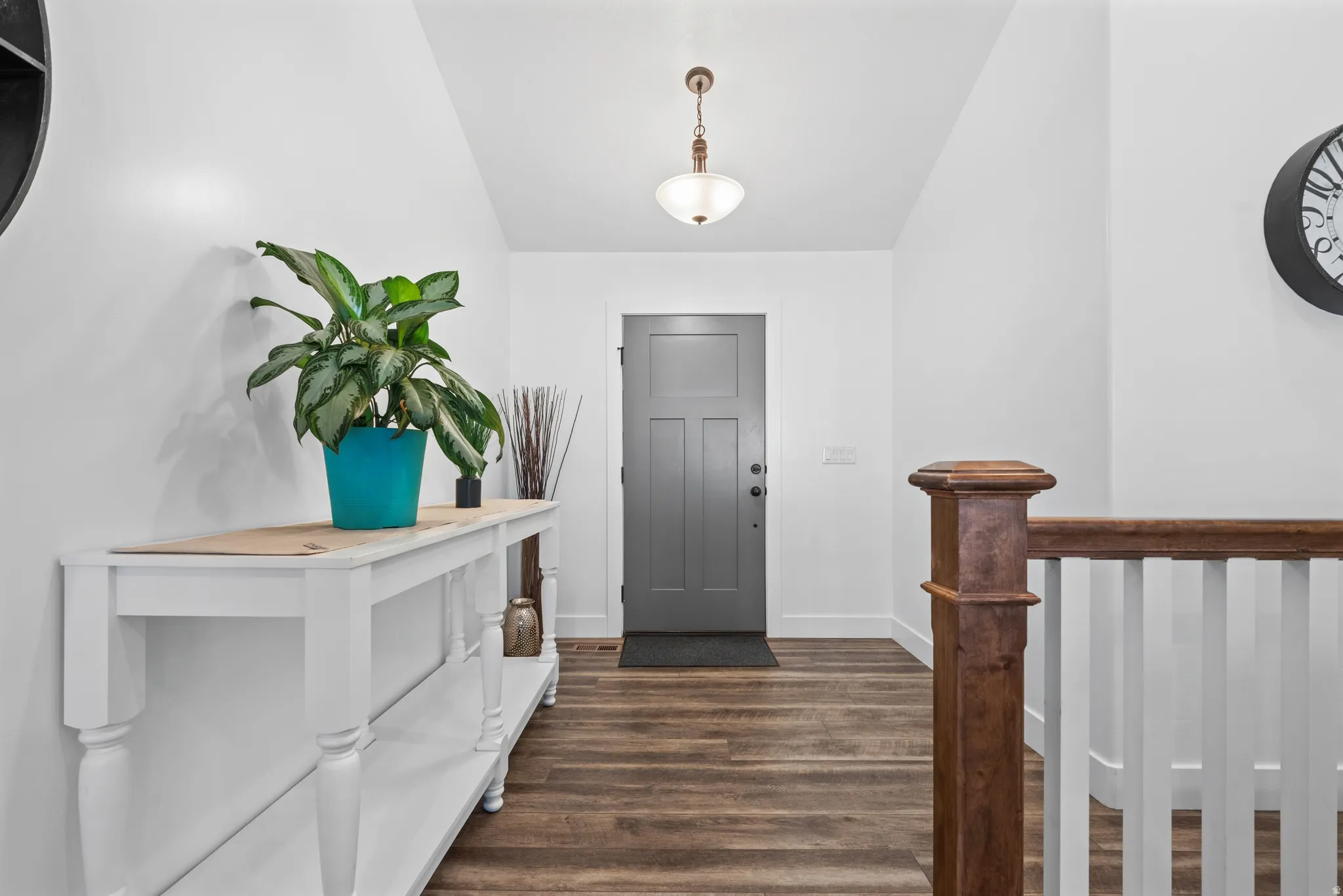 Entryway featuring wood-finish flooring and a dark gray paneled door