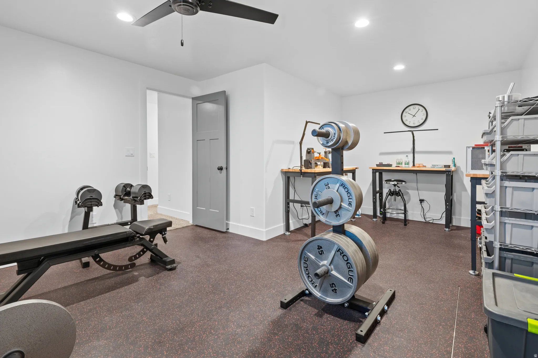 Spacious room with dark rubber flooring, recessed lighting, and a ceiling fan