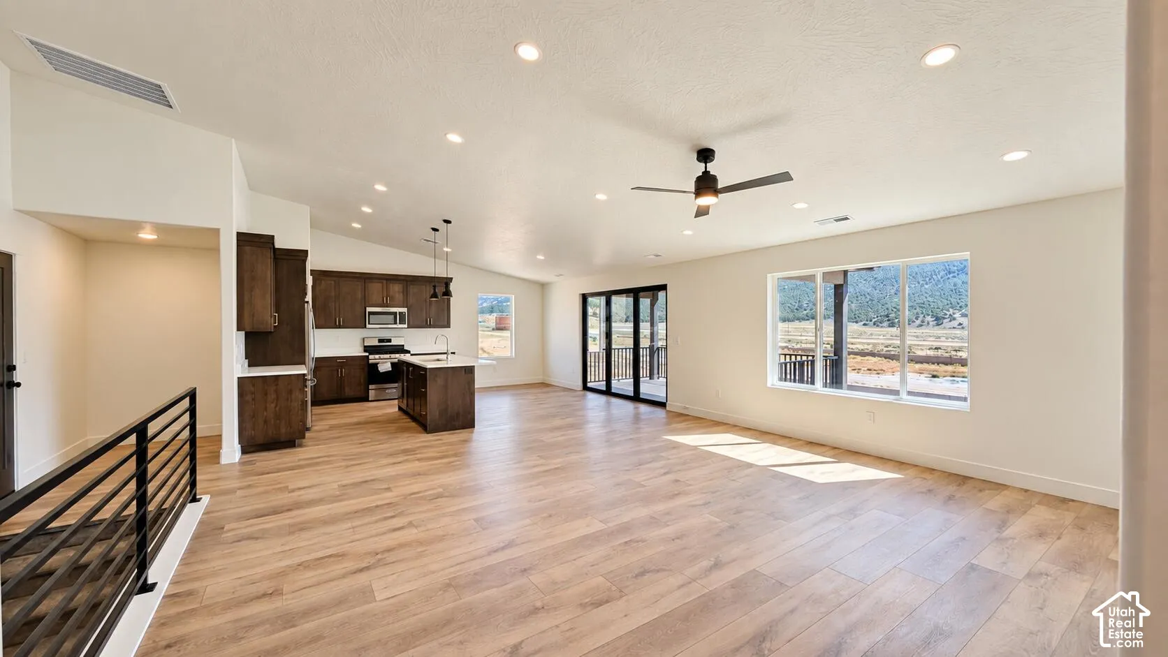 Open-concept living area featuring wood-finish flooring, recessed lighting, and a contemporary ceiling fan