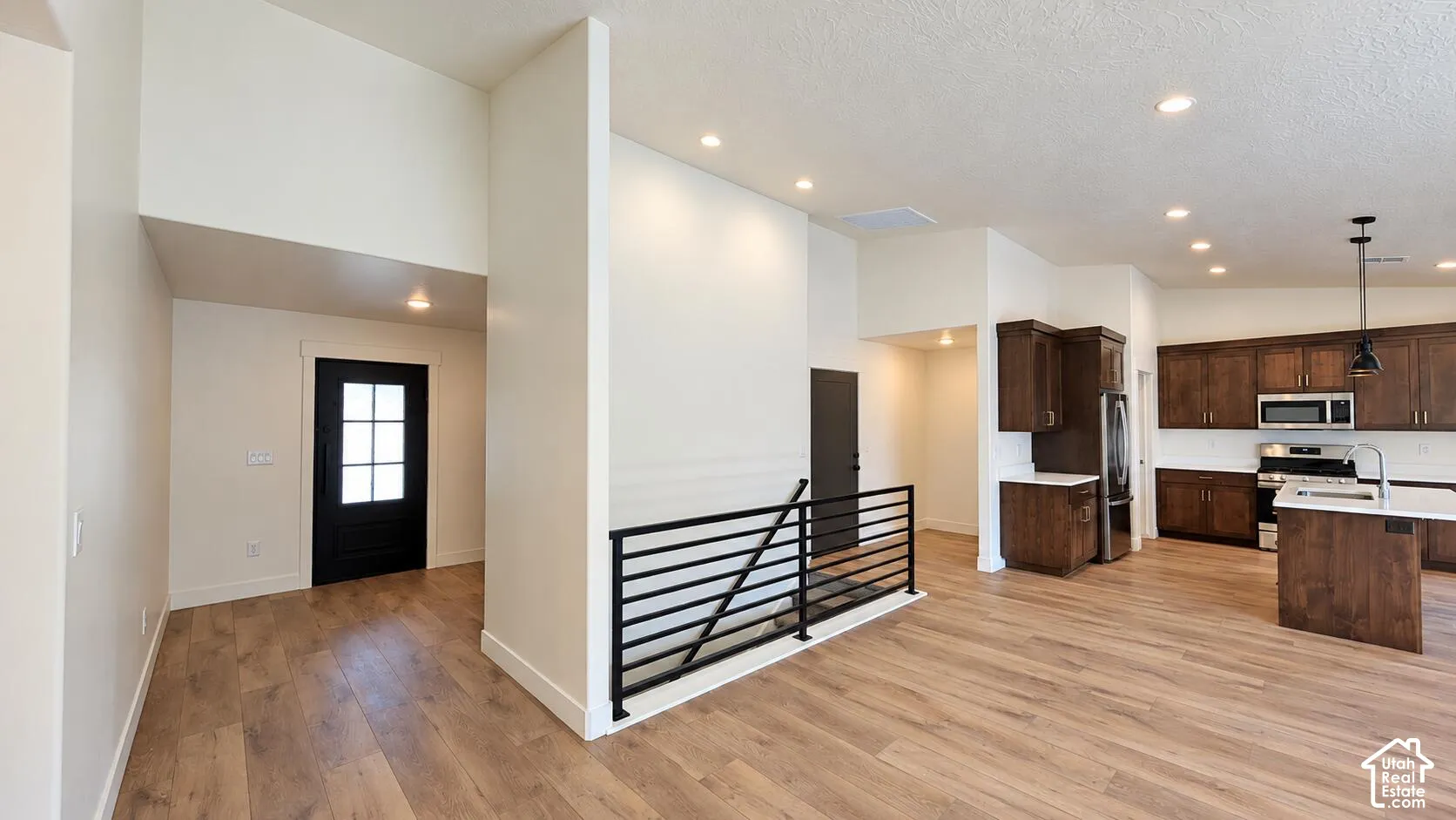 Open-concept living space with wood-finish flooring, recessed lighting, and a modern kitchen