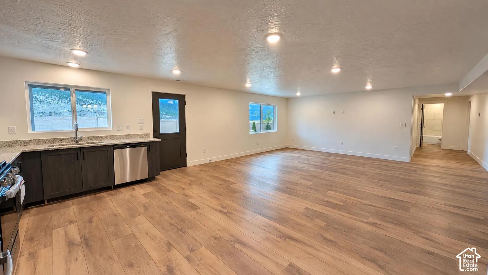 Open-concept living area featuring wood-finish flooring, recessed lighting, and white walls