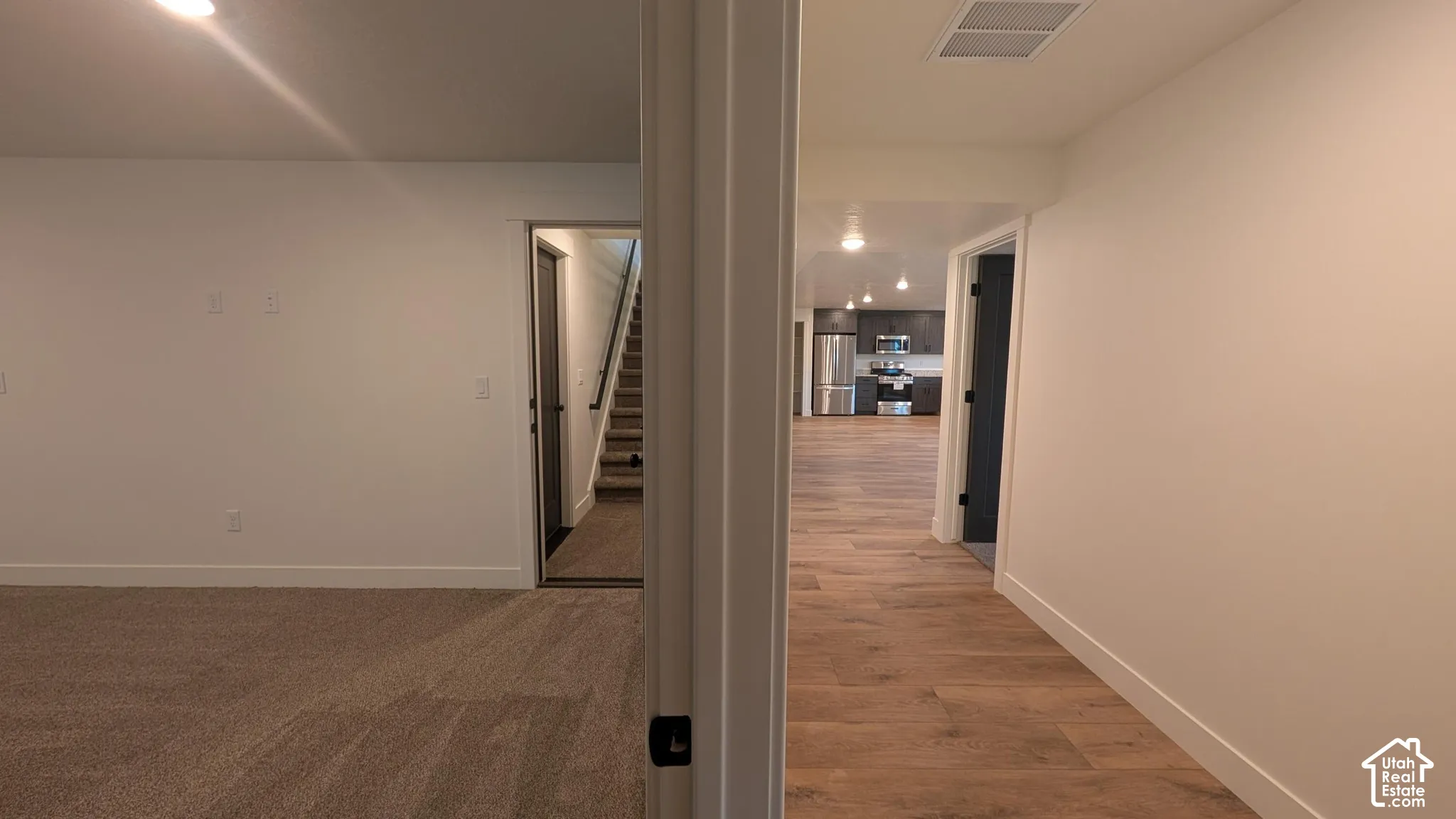 Wood-finish flooring, recessed lighting, and crisp white walls