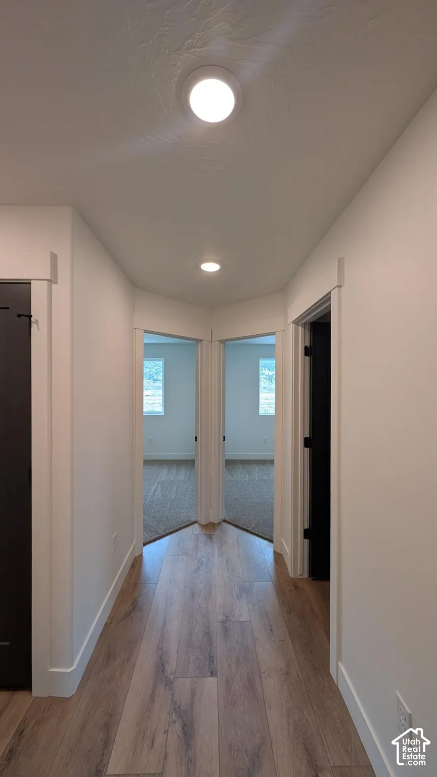 Wood-finish flooring, recessed lighting, white walls, and white trim