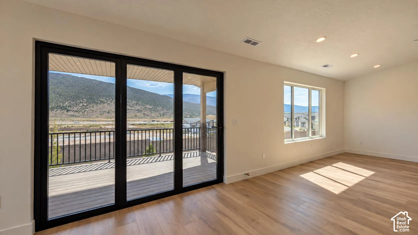 Expansive folding glass doors opening to a large outdoor deck, surrounded by a metal railing