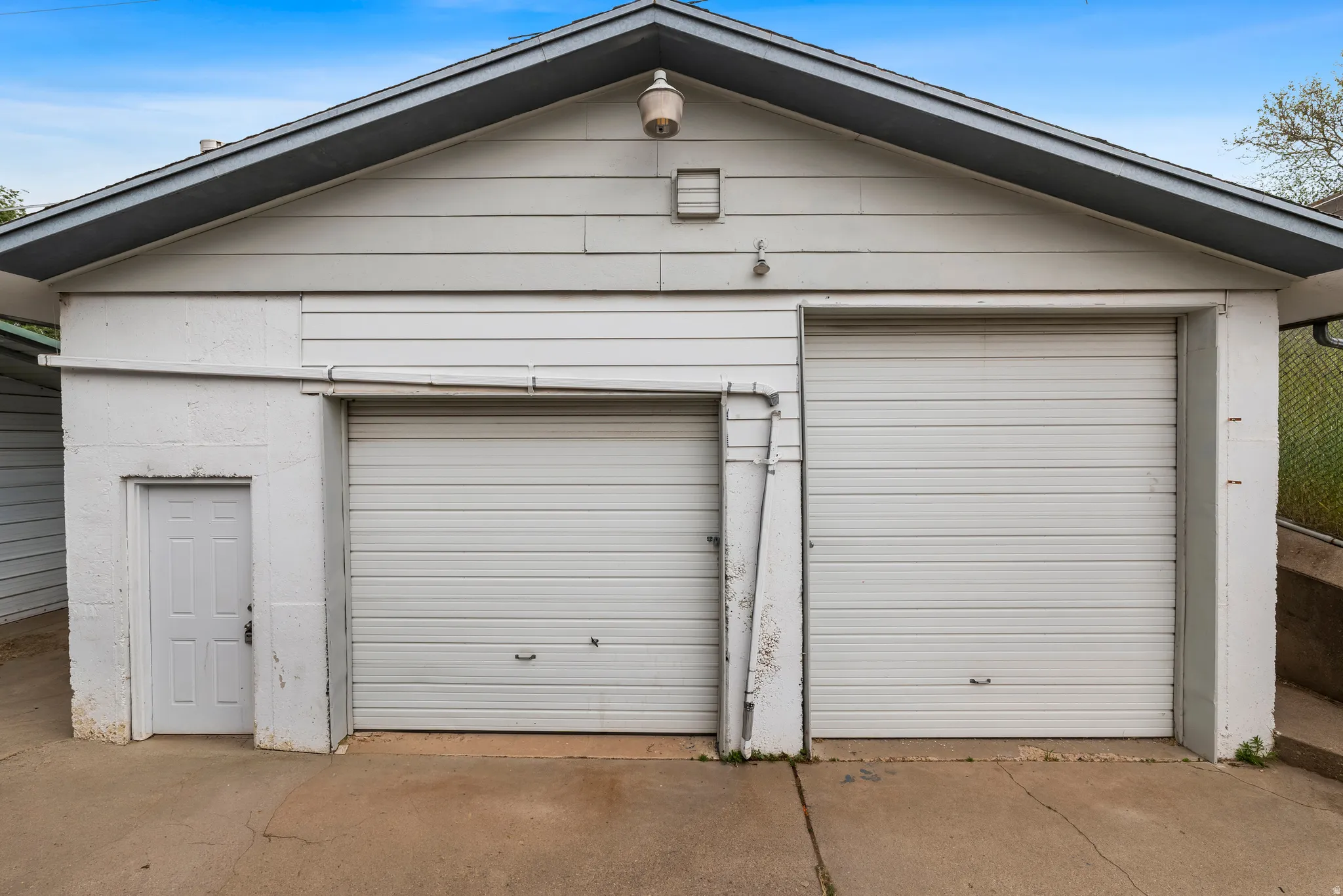 Attached garage featuring two overhead doors and a pedestrian entry door