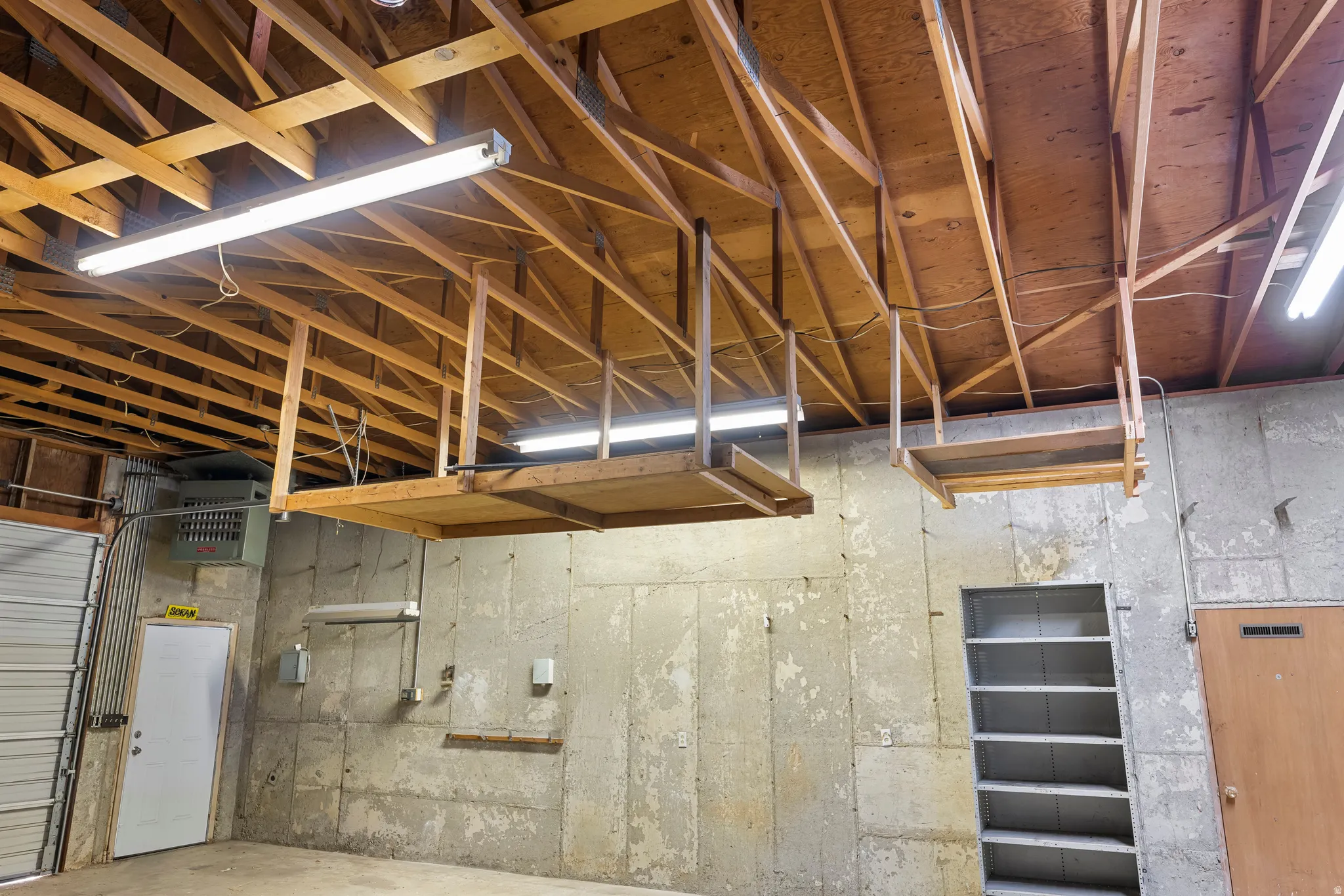 Spacious interior featuring exposed wood ceiling trusses and concrete walls