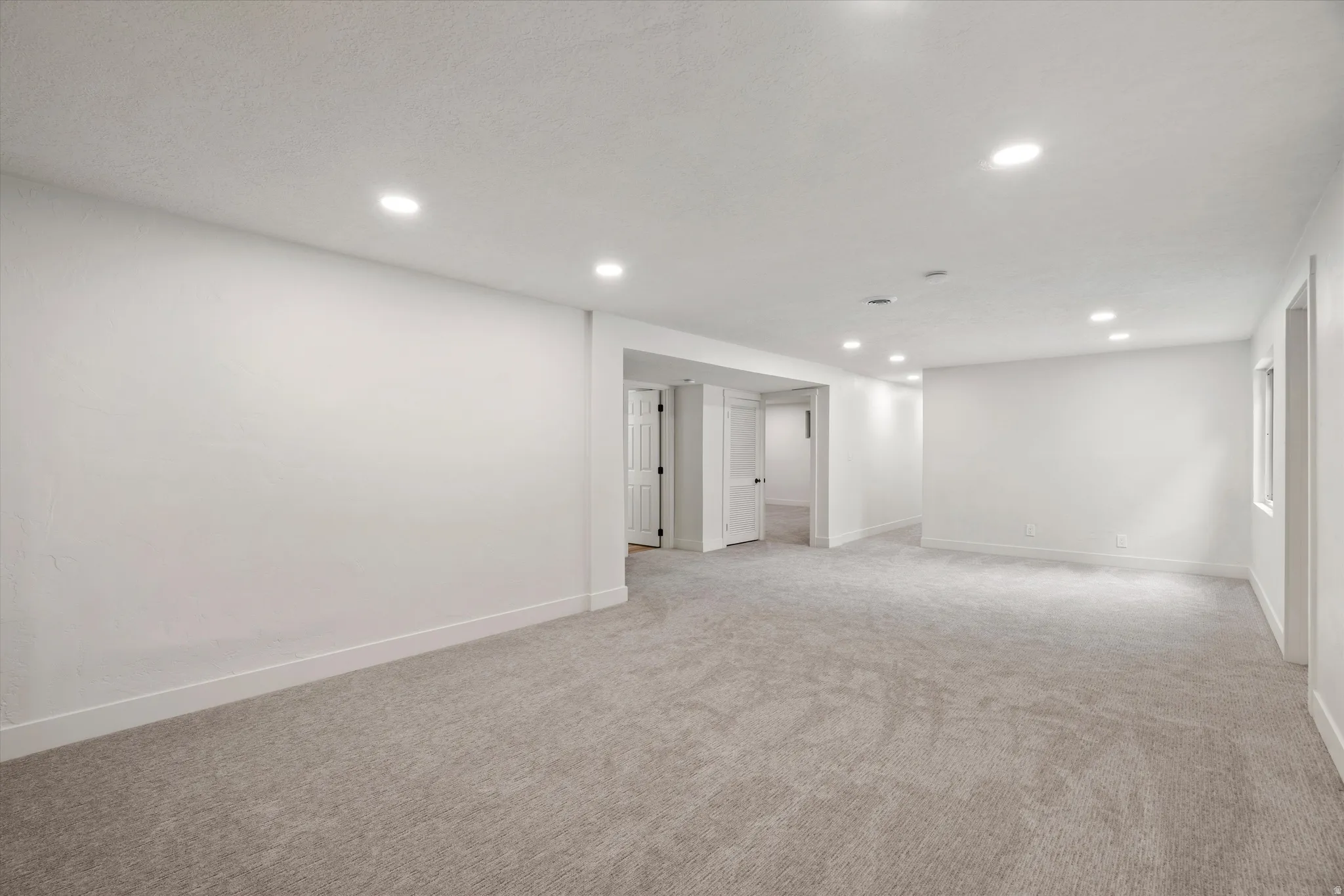 Spacious room featuring new carpeting, recessed lighting, white walls, and white trim