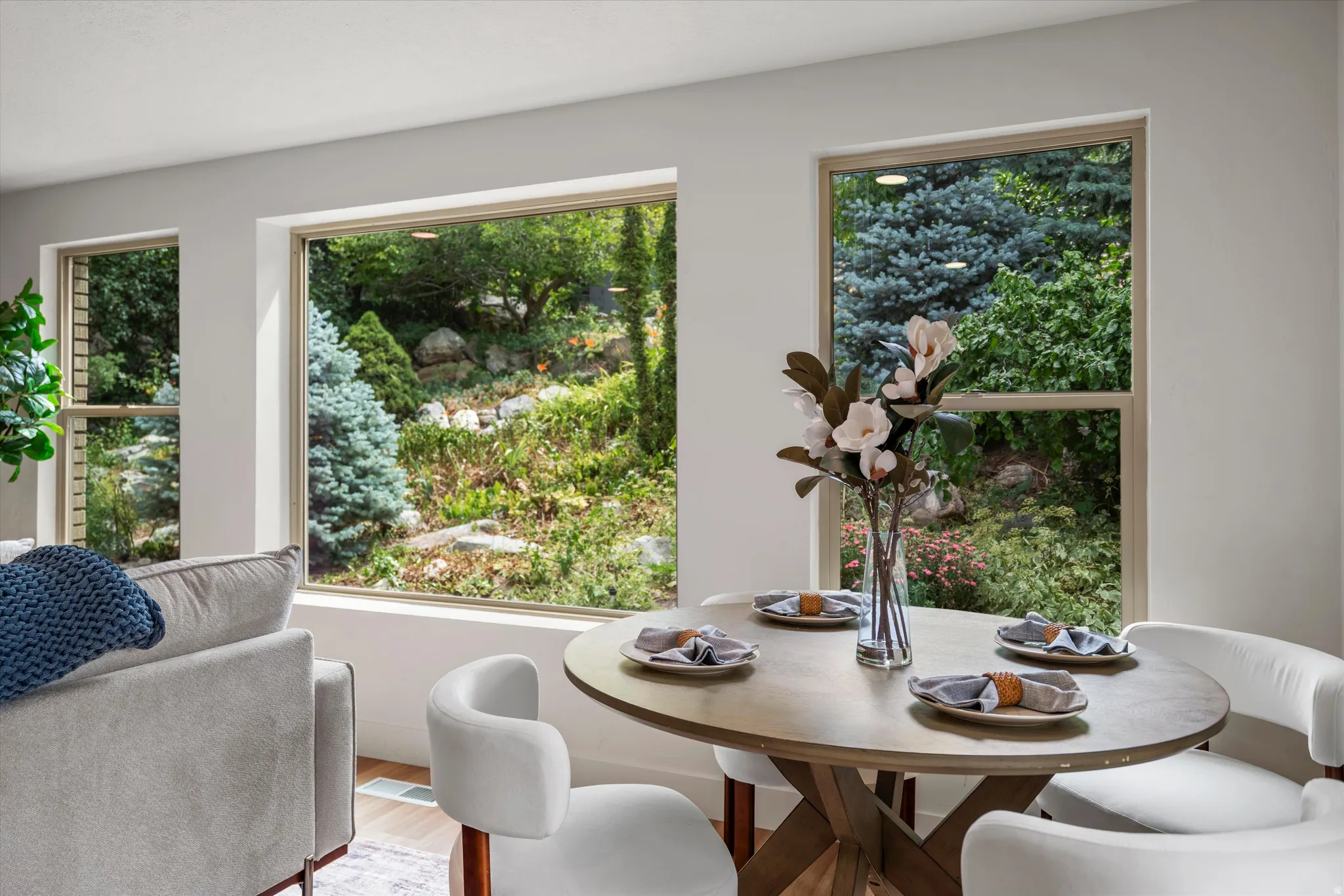 Dining area featuring multiple large windows, wood-finish flooring, and white walls