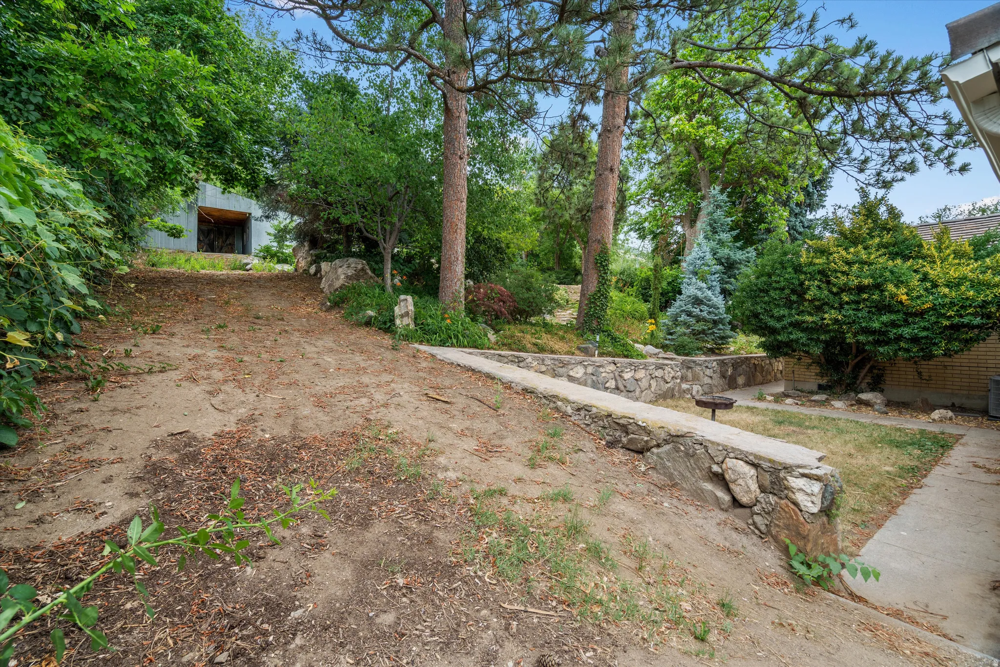 Tiered landscaping featuring stone retaining walls and mature trees