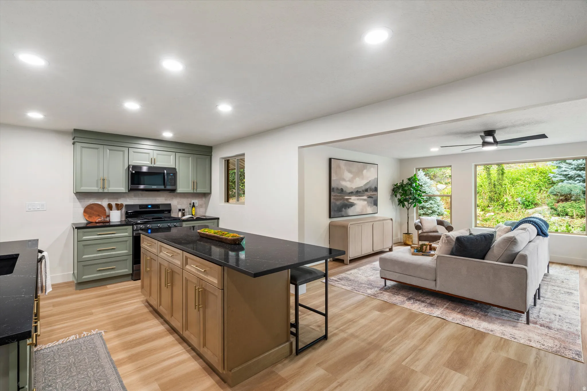 Open-concept living space featuring wood-finish flooring, recessed lighting, and a modern ceiling fan