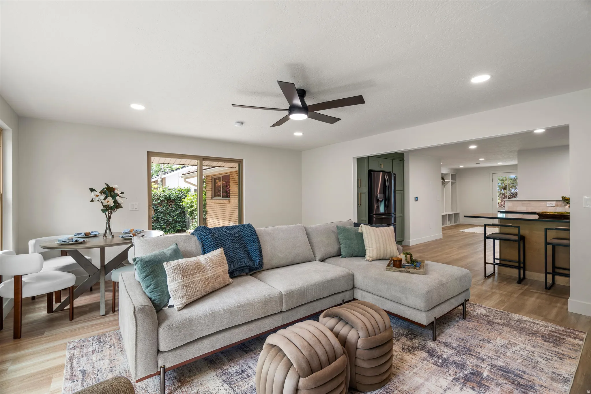 Open-concept living space featuring wood-finish flooring, recessed lighting, and a contemporary ceiling fan