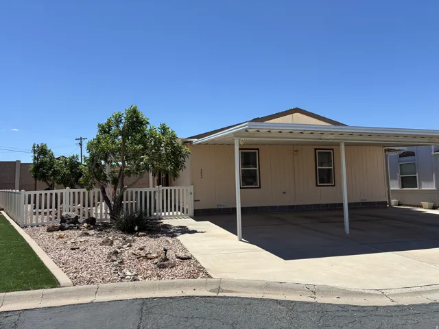 Exterior features a 3-car carport with concrete paving and beautiful landscaping