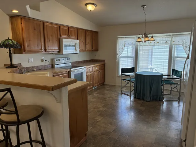 Kitchen featuring wood cabinetry, built-in microwave, and a breakfast bar