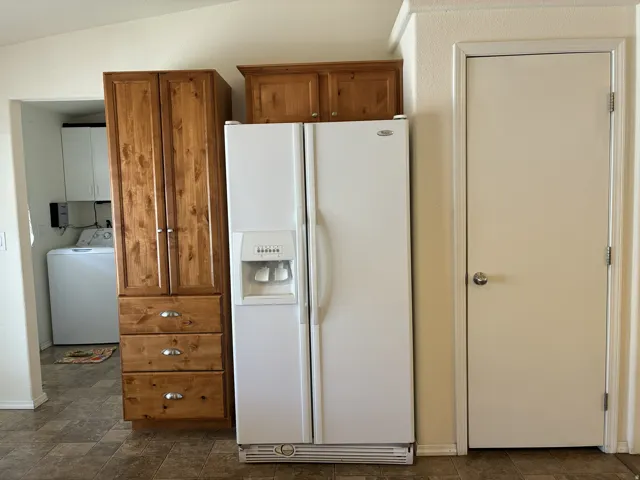 Kitchen area featuring wood-finish cabinetry with silver hardware and a pantry closet
