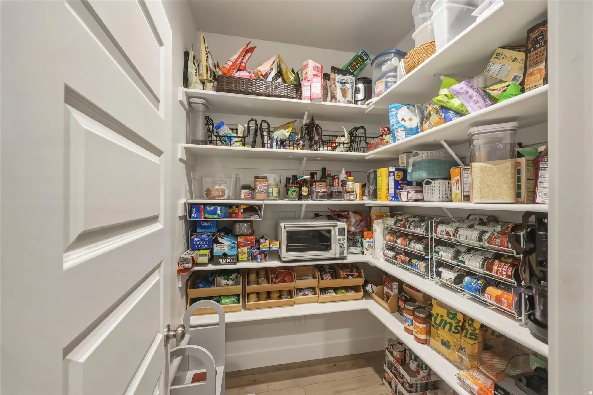 Spacious walk-in pantry featuring multiple levels of built-in shelving, providing extensive storage capacity