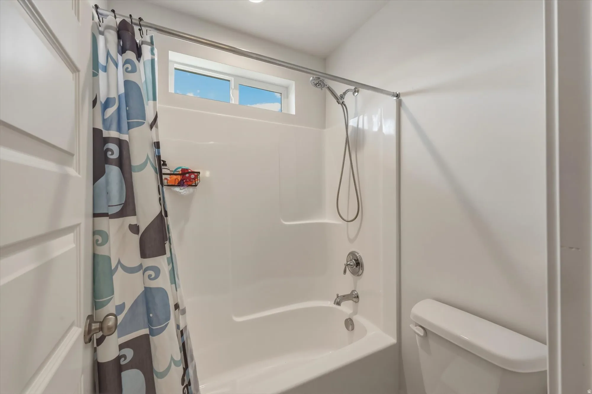 White tub and shower combination with a fixed showerhead, handheld sprayer, and chrome fixtures