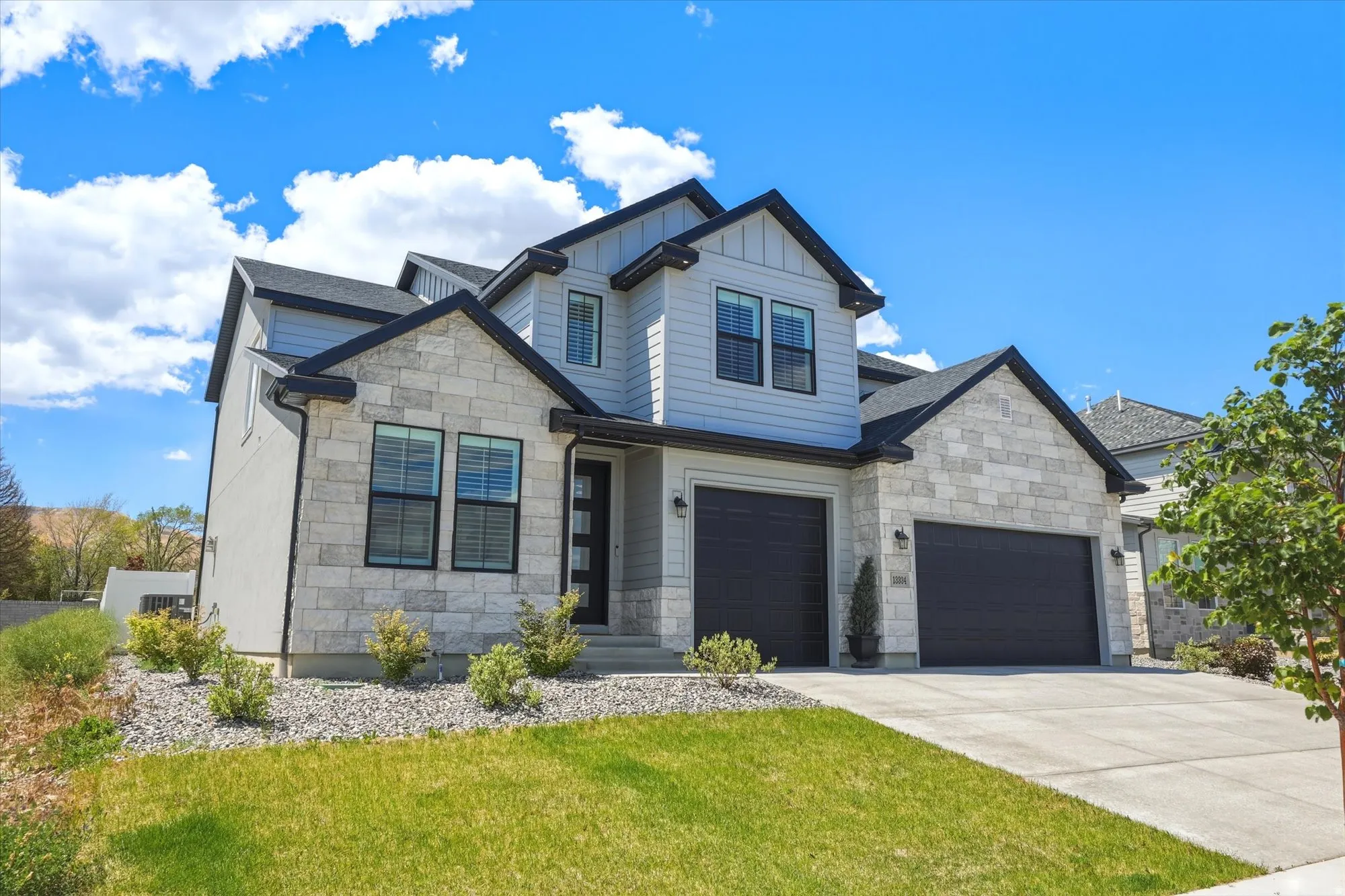 Contemporary two-story residence featuring light stone and siding exterior