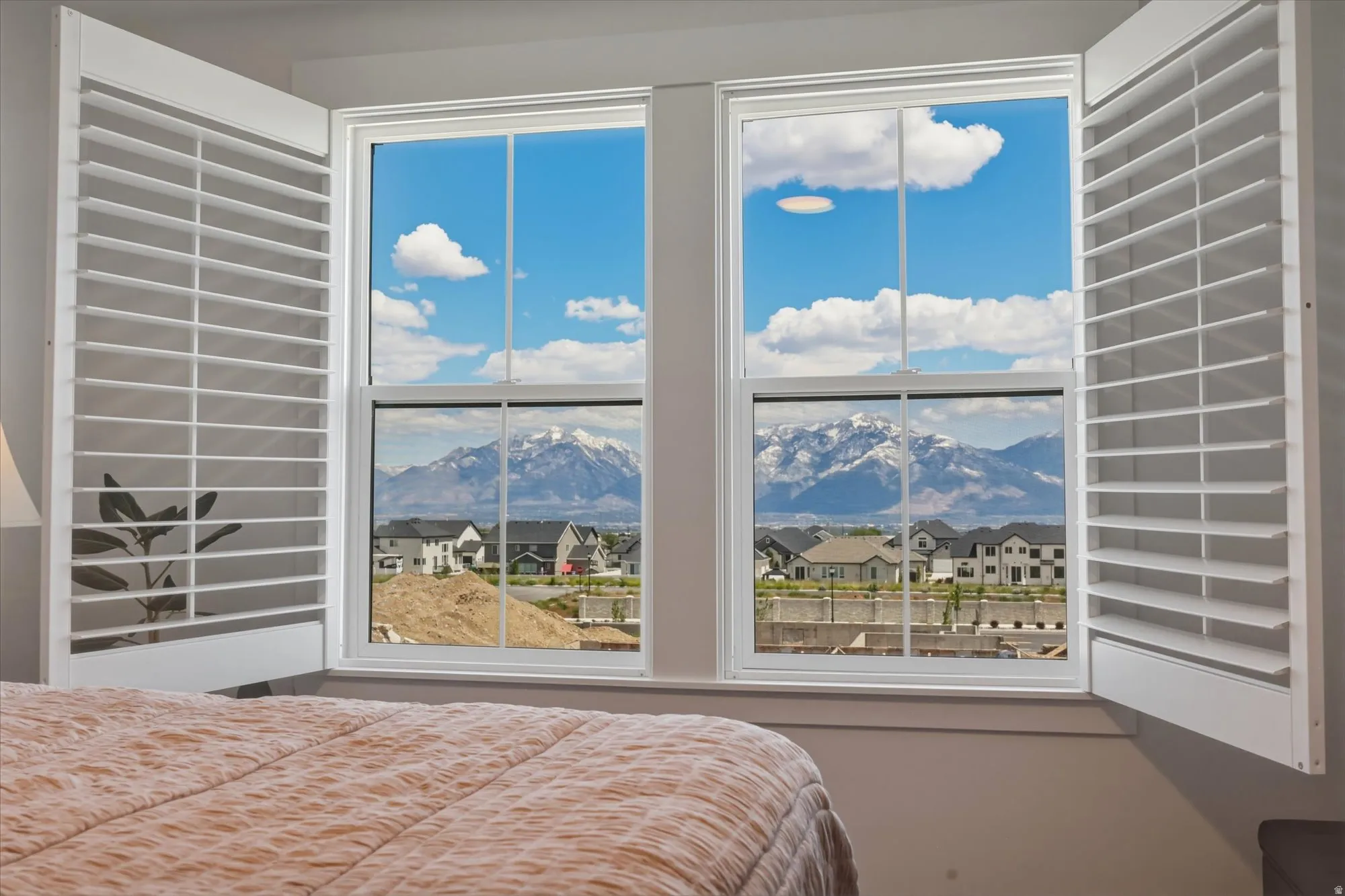Double-hung windows with white frames and plantation shutters