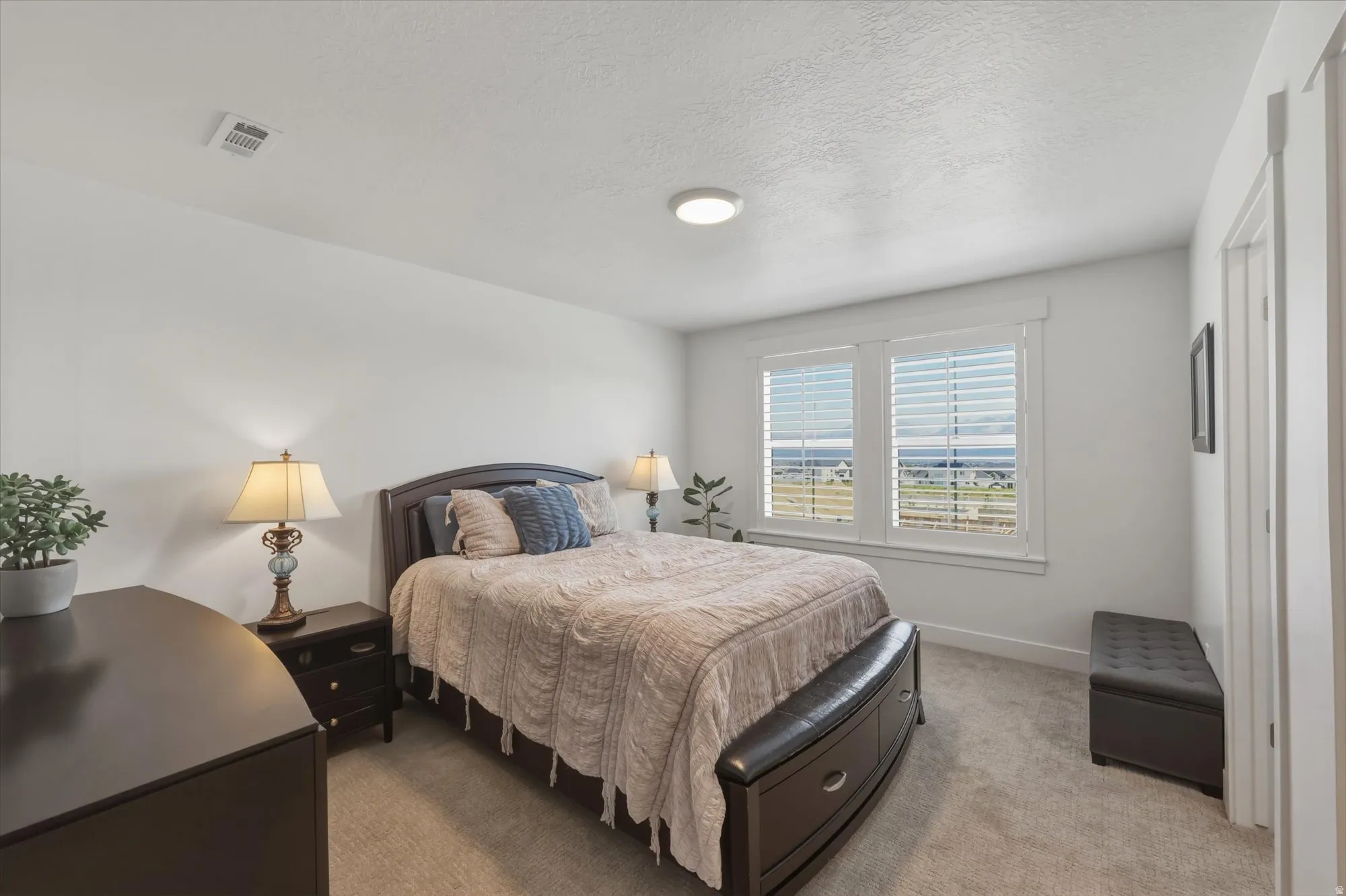 Bedroom with white walls and light-colored carpet flooring