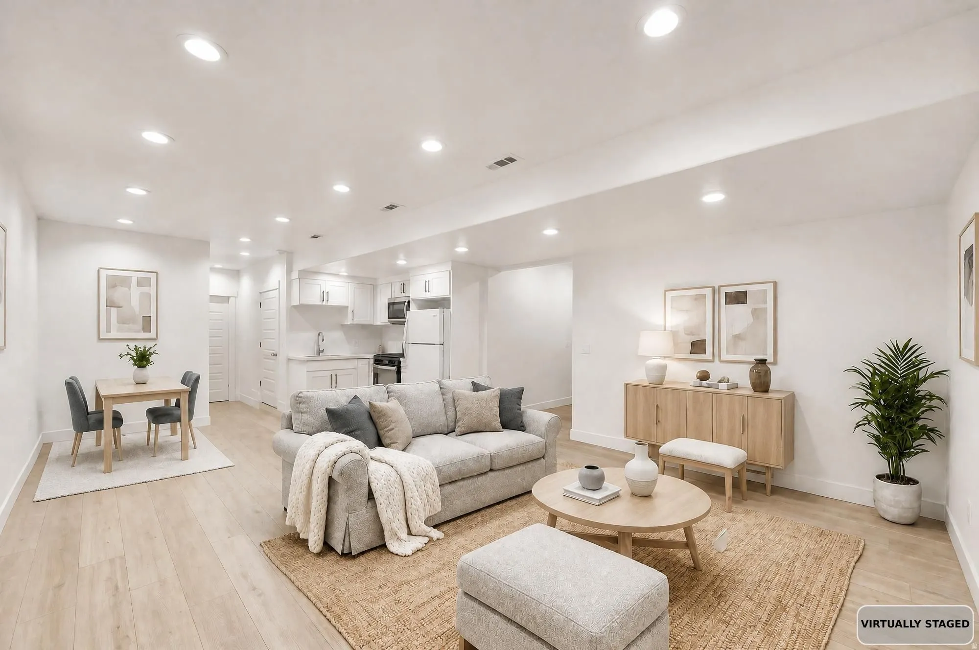 Virtually staged basement apartment.. Open-concept living space featuring wood-finish flooring and recessed lighting