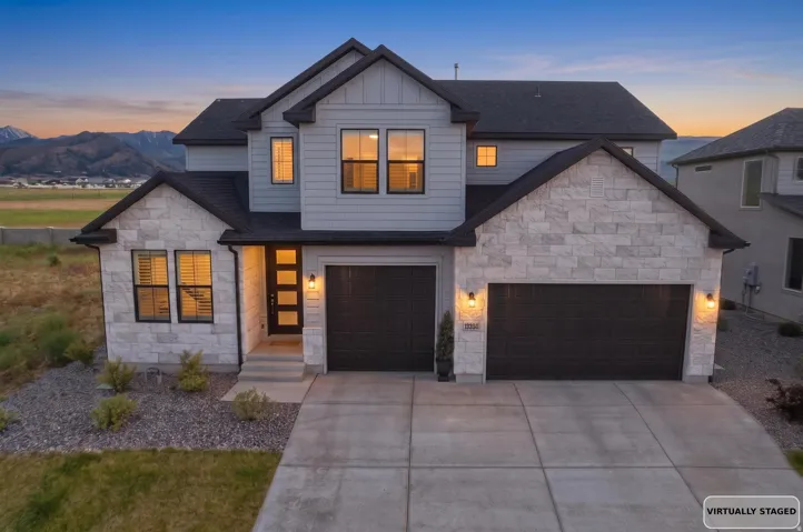 Modern two-story residence featuring a combination of light-toned stone veneer and gray horizontal siding