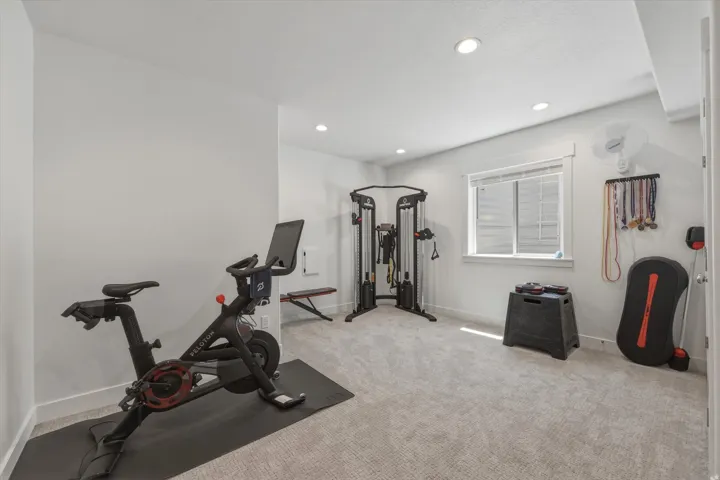 Dedicated exercise room featuring light gray carpeting and white walls
