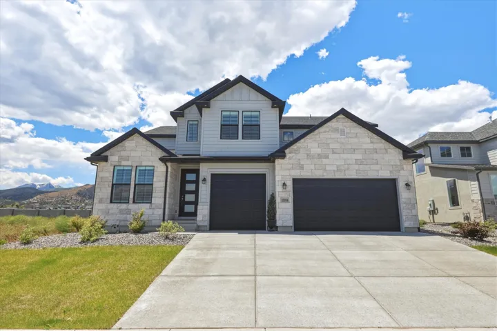 Contemporary two-story residence featuring light stone veneer and light gray siding
