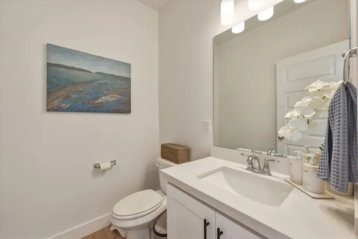 Bathroom featuring a white vanity with an integrated sink, polished chrome faucet, and a wall-mounted rectangular mirror