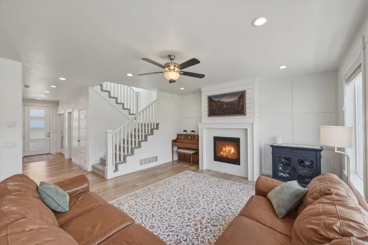 Bright living area featuring a modern fireplace with a shiplap accent wall and a classic white mantel