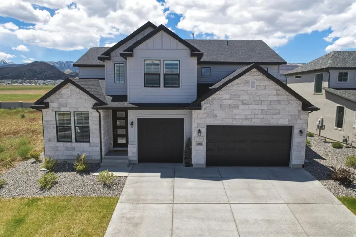 Modern contemporary facade featuring light gray siding and light-colored stone accents