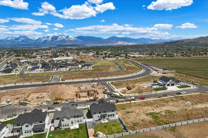 Expansive aerial perspective showcasing a developing residential area with snow-capped mountains in the background